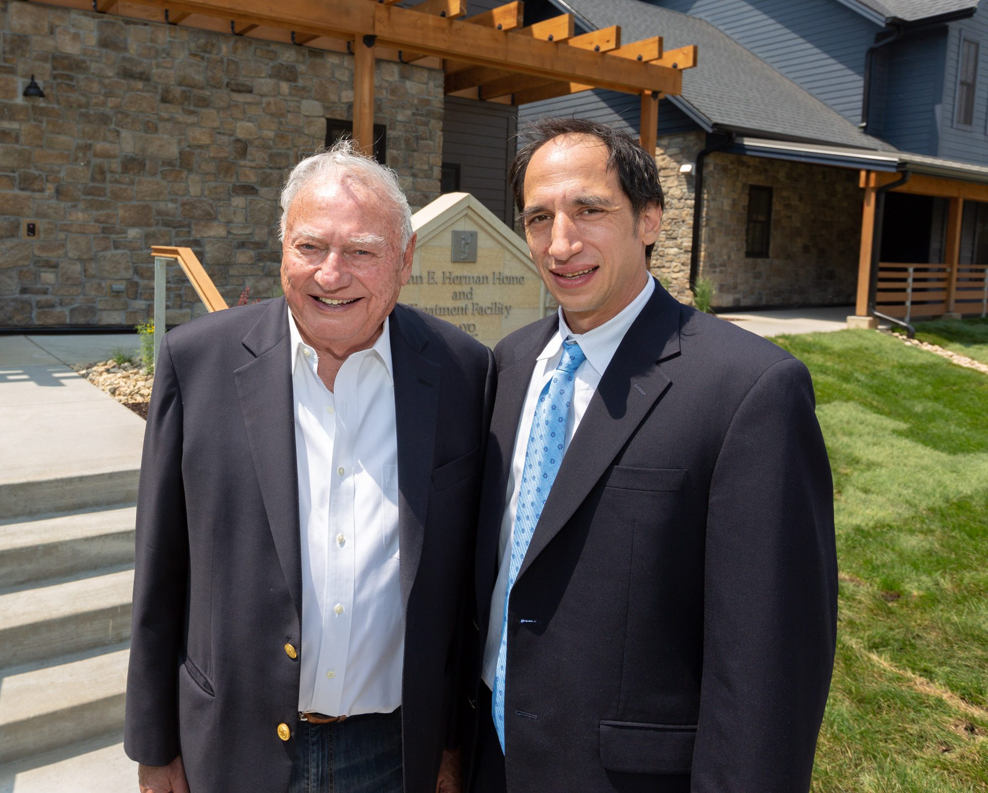 Chic and John Herman standing in front of the John E. Herman Home and Treatment Facility